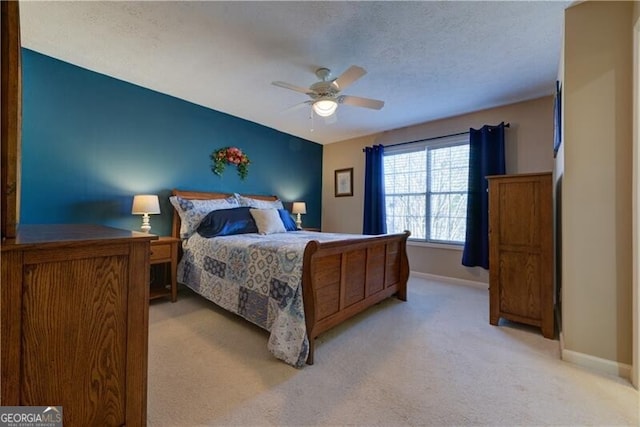 carpeted bedroom with ceiling fan and a textured ceiling