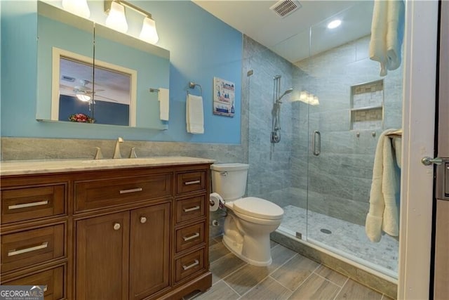 bathroom with vanity, toilet, and a shower with door