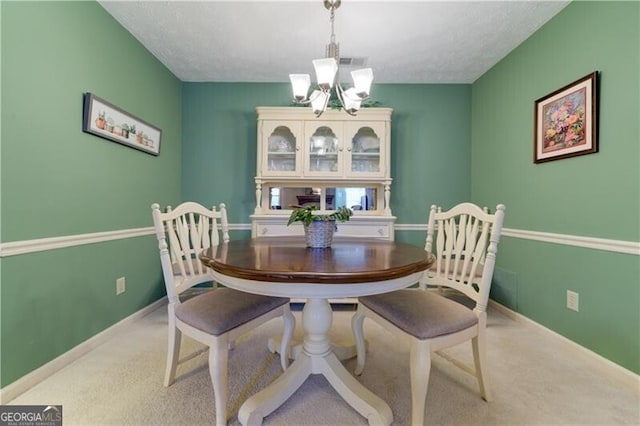 dining space with light carpet, a textured ceiling, and an inviting chandelier