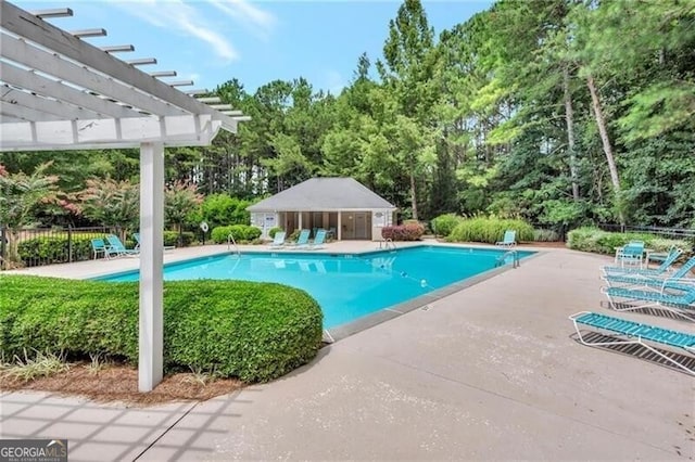 view of pool featuring an outbuilding, a pergola, and a patio