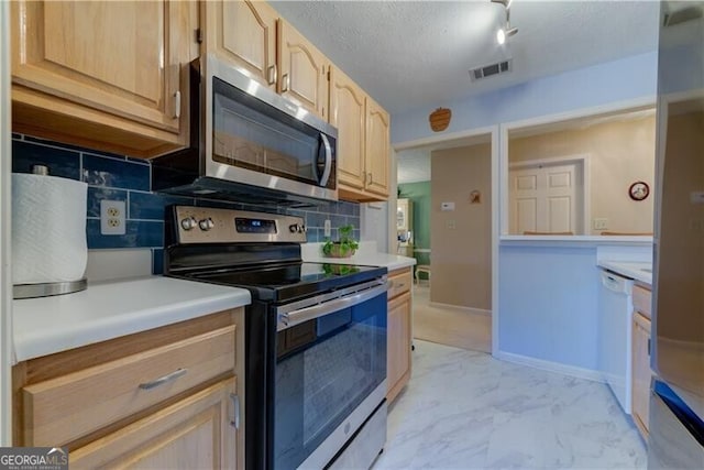 kitchen with appliances with stainless steel finishes, backsplash, a textured ceiling, and light brown cabinetry