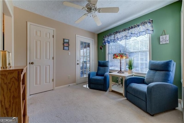 living area with carpet flooring, a textured ceiling, and ceiling fan