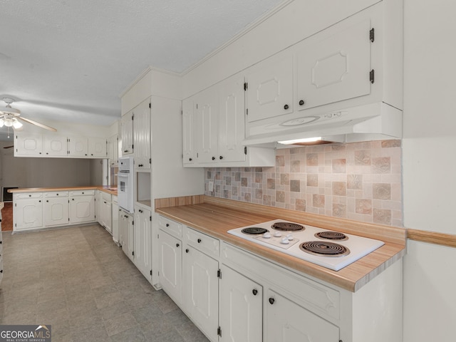 kitchen with backsplash, white cabinets, ceiling fan, kitchen peninsula, and white appliances