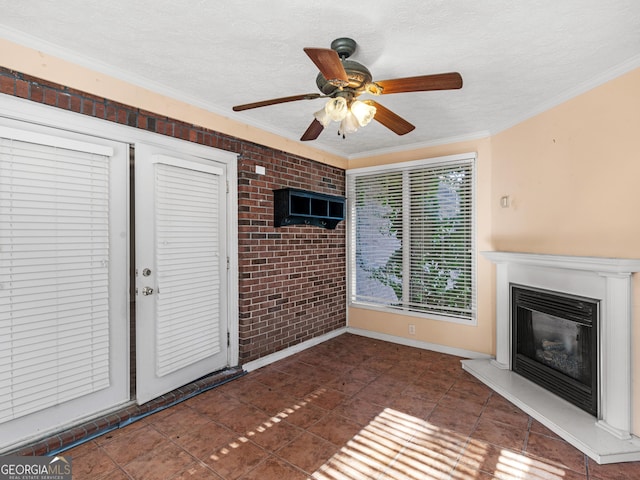 unfurnished living room featuring dark tile patterned floors, crown molding, brick wall, and ceiling fan