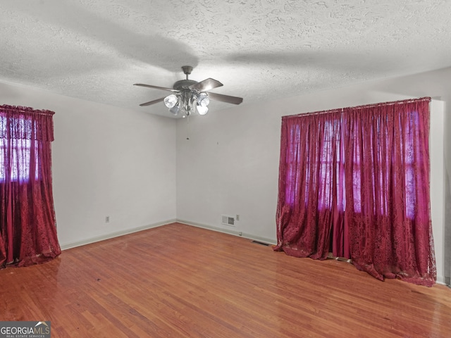 spare room with ceiling fan, hardwood / wood-style floors, and a textured ceiling