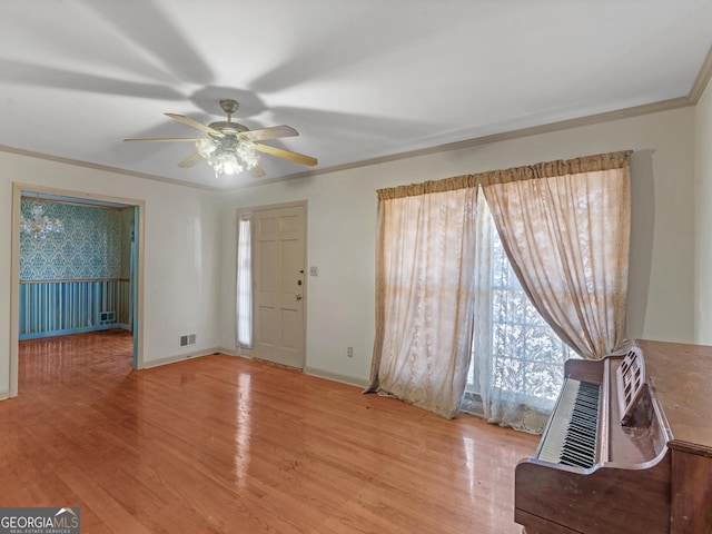 foyer entrance featuring ornamental molding, light hardwood / wood-style floors, and ceiling fan