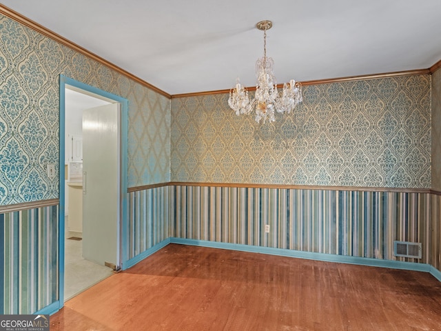 unfurnished room with crown molding, wood-type flooring, and a notable chandelier