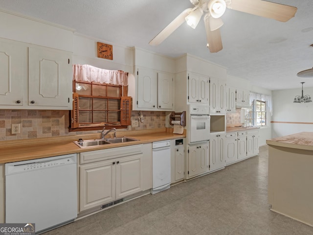 kitchen featuring sink, backsplash, white cabinets, and white appliances