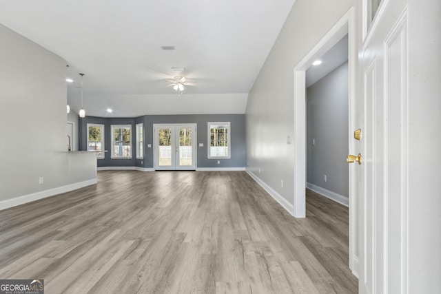 unfurnished living room with french doors, light wood-type flooring, ceiling fan, and lofted ceiling