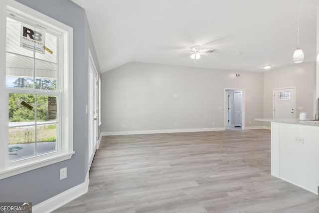 interior space with sink, vaulted ceiling, and light wood-type flooring