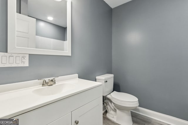 bathroom featuring hardwood / wood-style floors, vanity, and toilet