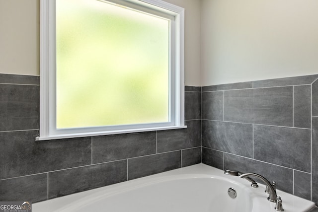 bathroom with a tub and a wealth of natural light