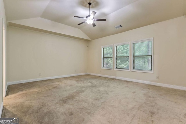 spare room with ceiling fan, lofted ceiling, and light carpet