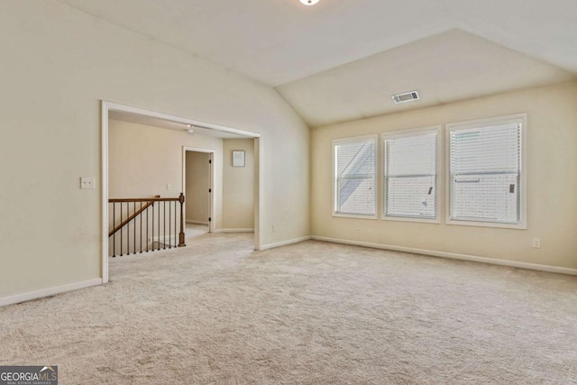 carpeted spare room with lofted ceiling