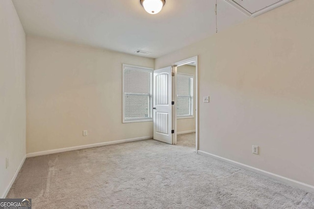 spare room featuring light colored carpet