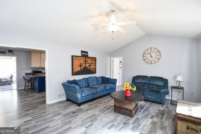 living room featuring ceiling fan, vaulted ceiling, and hardwood / wood-style floors