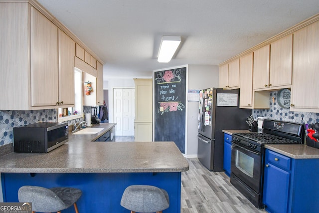 kitchen featuring kitchen peninsula, stainless steel appliances, light brown cabinetry, backsplash, and sink