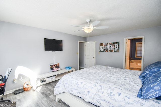 bedroom with ceiling fan, ensuite bathroom, a textured ceiling, and wood-type flooring