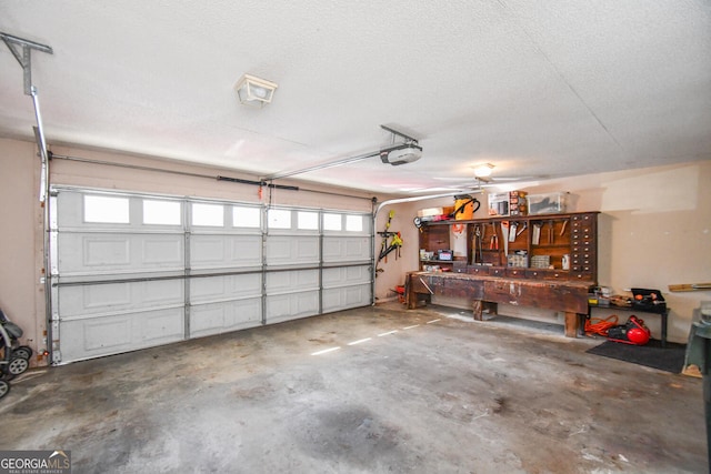 garage with a workshop area and a garage door opener