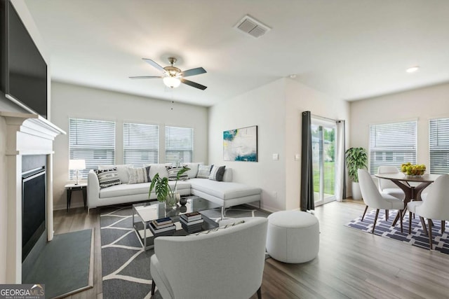 living room featuring ceiling fan and dark wood-type flooring