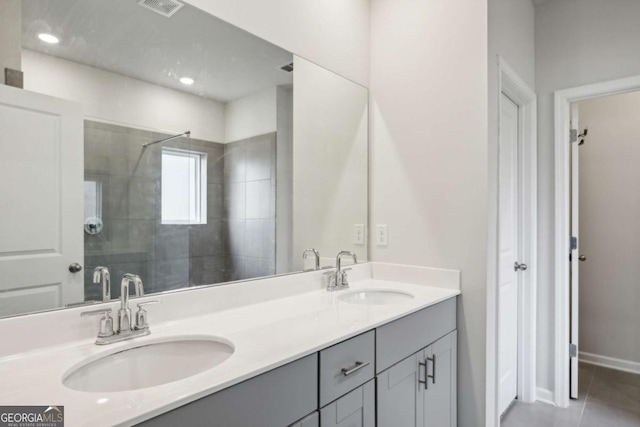 bathroom with tile patterned floors, vanity, and walk in shower