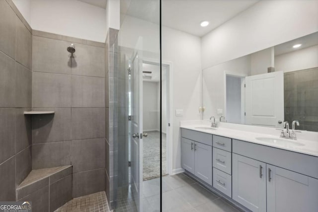 bathroom with tile patterned flooring, vanity, and tiled shower