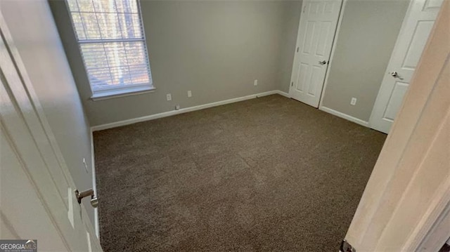 unfurnished bedroom featuring dark carpet