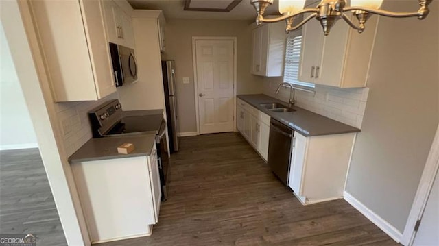 kitchen featuring white cabinets, sink, dark hardwood / wood-style flooring, stainless steel appliances, and a chandelier