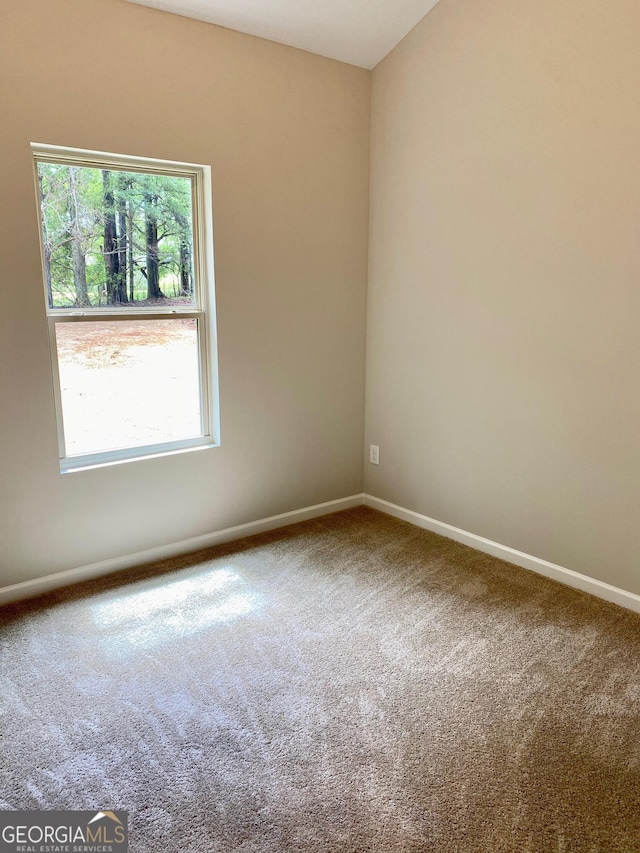 carpeted spare room with baseboards