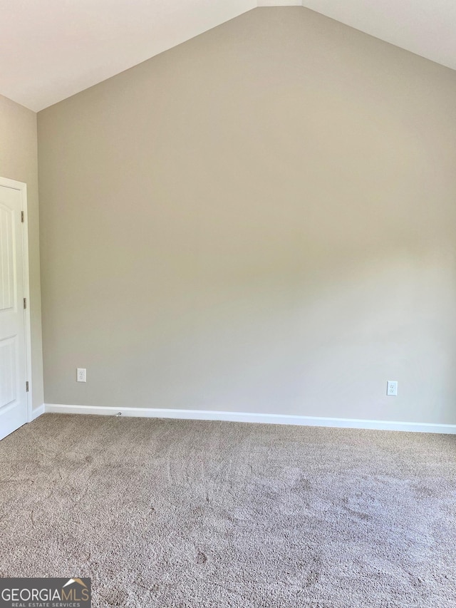 carpeted empty room with lofted ceiling and baseboards