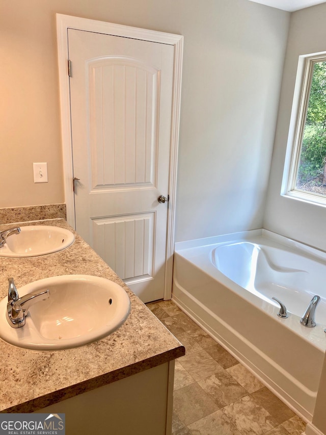 full bath with a bath, double vanity, and a sink