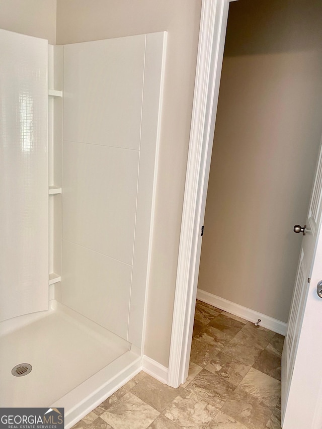 bathroom featuring baseboards and walk in shower