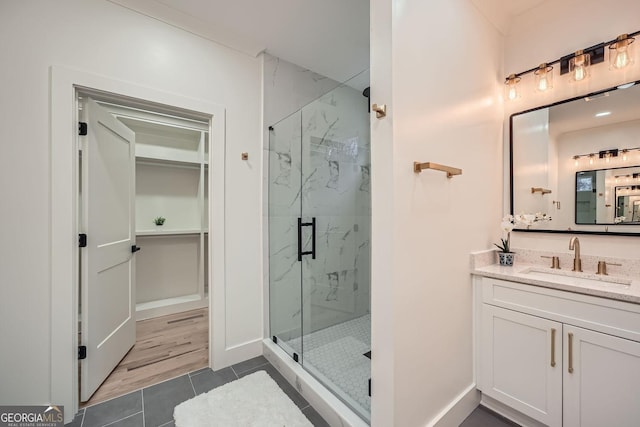 bathroom featuring a shower with door, vanity, and tile patterned floors