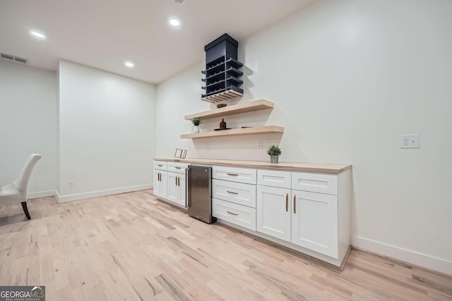 kitchen with white cabinetry, wood counters, and light hardwood / wood-style floors