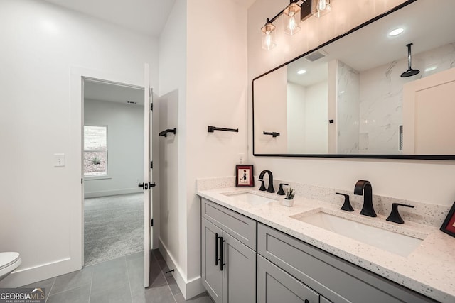 bathroom with vanity, tile patterned flooring, toilet, and walk in shower