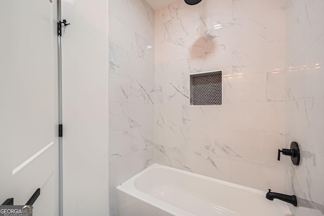 bathroom featuring tiled shower / bath