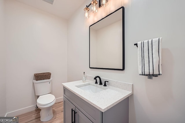 bathroom with vanity, hardwood / wood-style flooring, and toilet