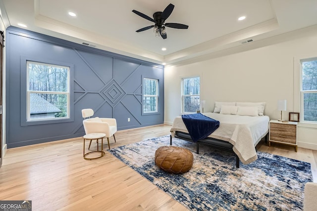 bedroom featuring a tray ceiling, ceiling fan, and hardwood / wood-style flooring