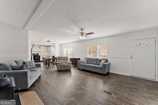 living room featuring ceiling fan and a textured ceiling