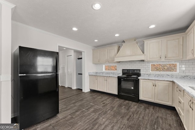 kitchen with cream cabinetry, black appliances, premium range hood, and dark hardwood / wood-style floors