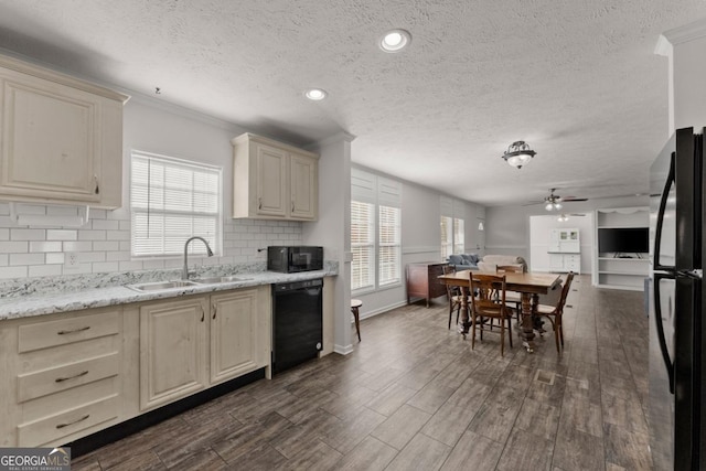 kitchen featuring cream cabinets, black appliances, decorative backsplash, ceiling fan, and sink