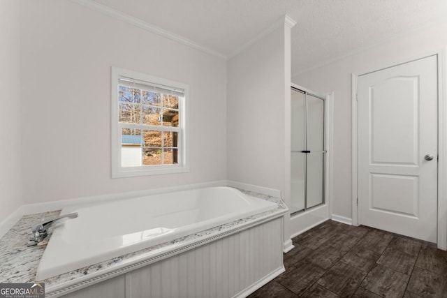 bathroom featuring a textured ceiling, ornamental molding, and separate shower and tub