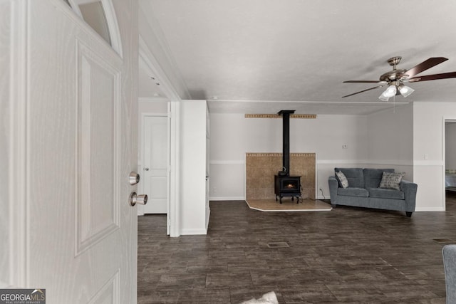 living room featuring ceiling fan and a wood stove