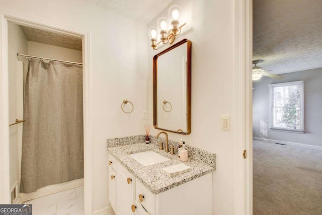 bathroom with a textured ceiling, vanity, ceiling fan, and curtained shower