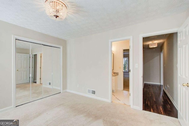 unfurnished bedroom with carpet flooring, a textured ceiling, and a closet