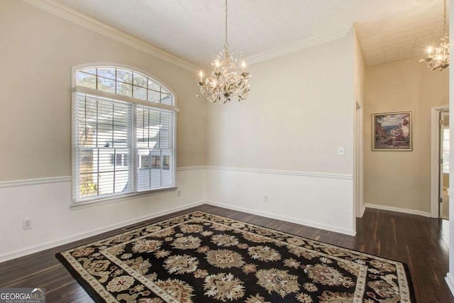 unfurnished room featuring crown molding, dark wood-type flooring, and a notable chandelier