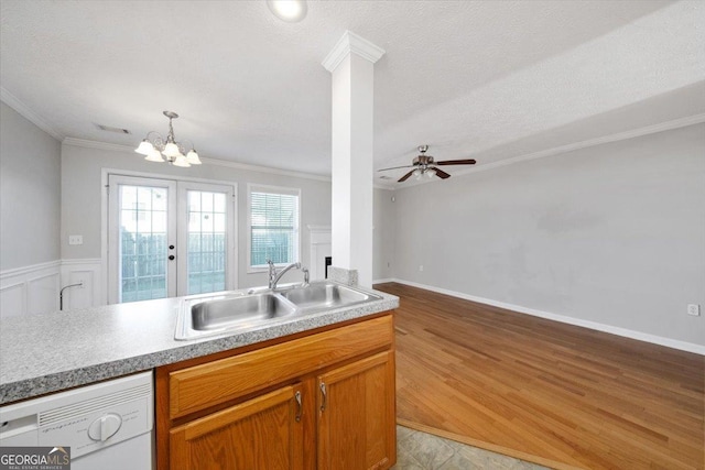 kitchen with ornamental molding, white dishwasher, a sink, light wood-type flooring, and ceiling fan with notable chandelier