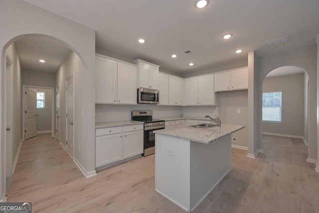 kitchen featuring a kitchen island with sink, sink, white cabinetry, and stainless steel appliances