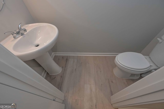 bathroom featuring hardwood / wood-style flooring and toilet