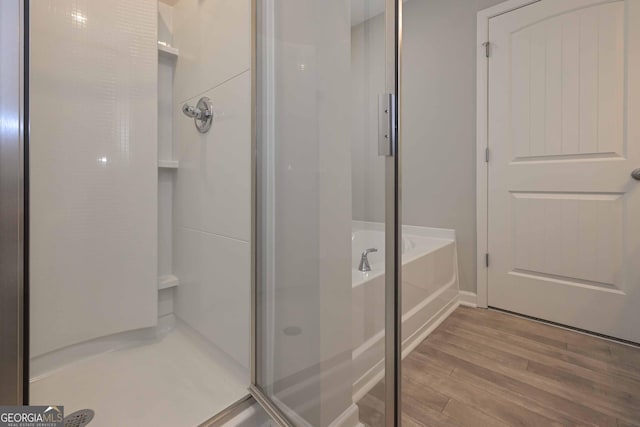 bathroom featuring independent shower and bath and hardwood / wood-style floors